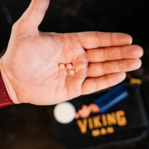 Man holding Finasteride pills in his hand.