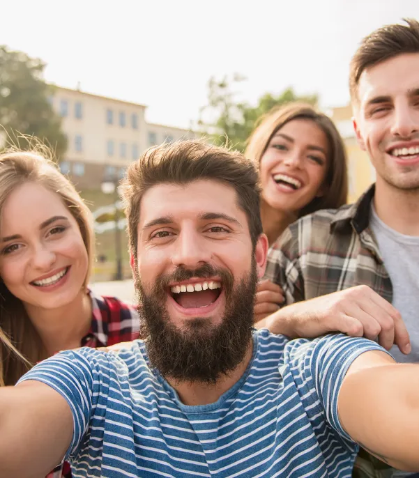 Selfie of two men and two women smiling on a sunny day.